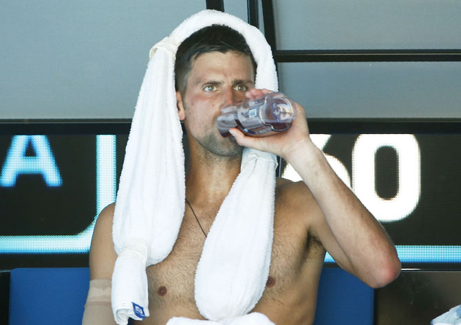 Novak Djokovic has a drink during a break in his match against Gael Monfils