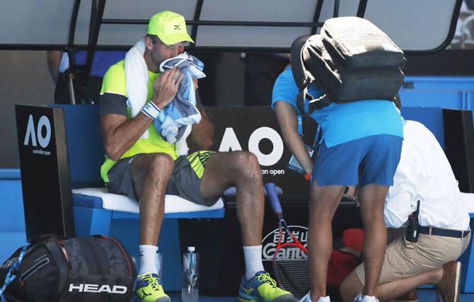 Croatia's Ivo Karlovic gets some assistance as he cools down during a break between games in his match against Italy's Andreas Seppi on Friday