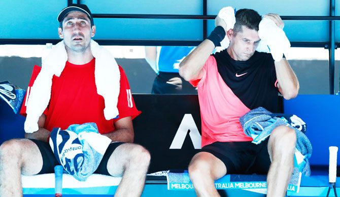 Austria's Philipp Oswald (left) and his doubles partner Belarus's Max Mirnyi look sapped out of energy during their second round men's doubles match against USA's the Bryan twins