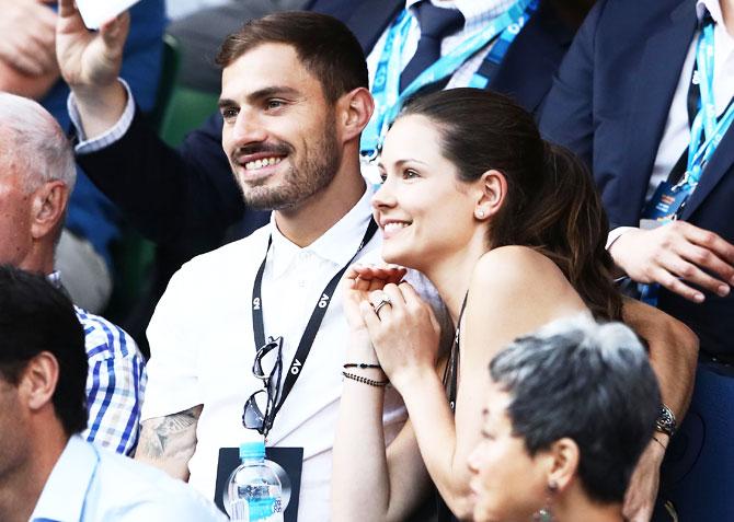 Melbourne Victory's A-League footballer James Troisi (left) and a friend, watch the fourth round clash that saw the South Korean Chung reach his first grand slam quarter-final