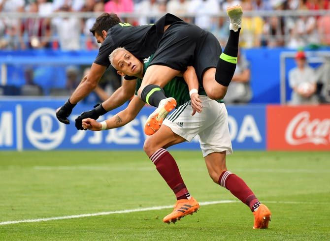 Mexico's Javier Hernandez collides with Brazil goalkeeper Alisson Becker