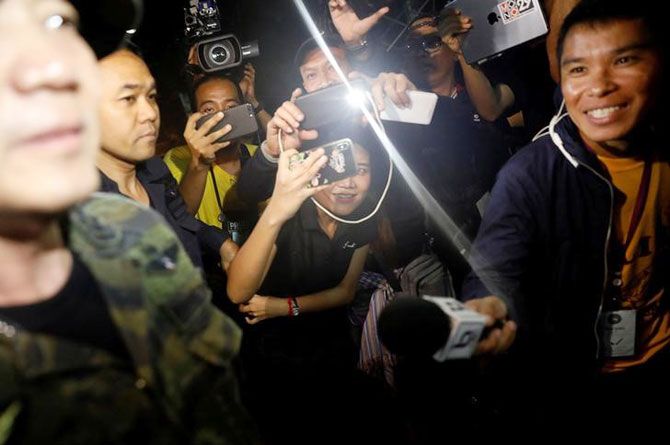 Journalists smile as they try to interview a military officer near the Tham Luang cave complex, as members of an under-16 soccer team and their coach have been found alive, according to a local media's report, in the northern province of Chiang Rai, Thailand on Monday
