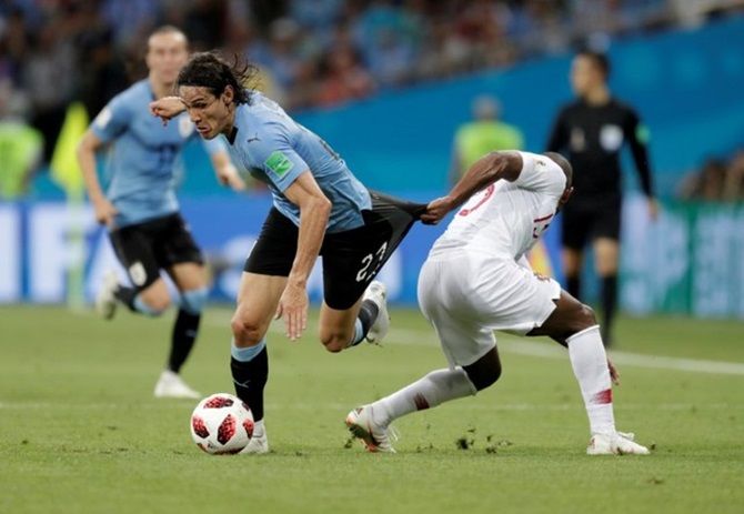 Uruguay's Edinson Cavani in checked by Portugal's Ricardo Pereira as he makes his way into the box
