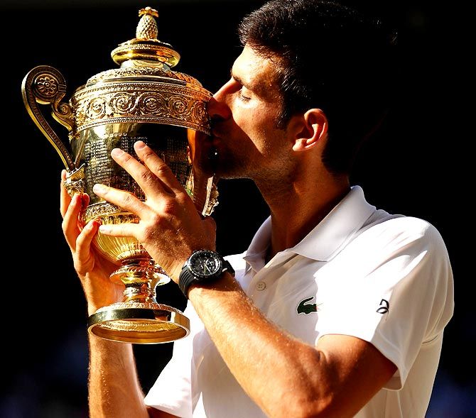 Novak Djokovic kisses the trophy after winning his fourth Wimbledon title