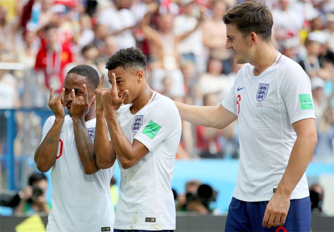 England's Jesse Lingard celebrates with teammates John Stones and Raheem Sterling after scoring his team's third goal against Panama in their Group G match