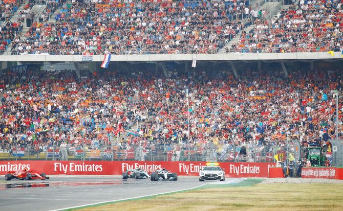Mercedes’ Lewis Hamilton leads the race behind the safety car during the German GP