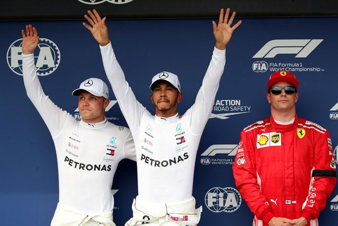 Mercedes' Lewis Hamilton (centre) celebrates after qualifying in pole position with second placed Mercedes' Valtteri Bottas (left) and third placed Ferrari's Kimi Raikkonen (right) after qualifying at the Hungarian F1 GP in Budapes on Saturday