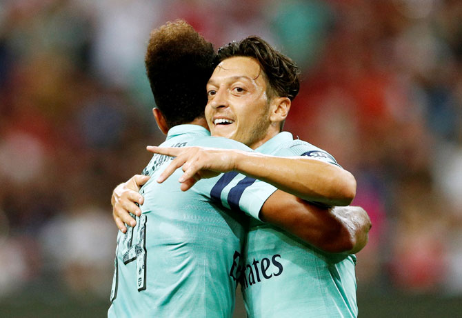 Arsenal's Mesut Ozil celebrates scoring their first goal with Pierre-Emerick Aubameyang during their International Champions Cup match against Paris St Germain at Singapore National Stadium, in Singapore on Saturday
