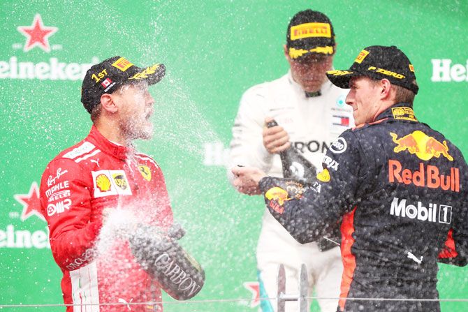 Race winner Sebastian Vettel of Germany and Ferrari and third place finisher Max Verstappen of Netherlands and Red Bull Racing celebrate on the podium after the Canadian Formula One Grand Prix at Circuit Gilles Villeneuve in Montreal, Canada, on Sunday