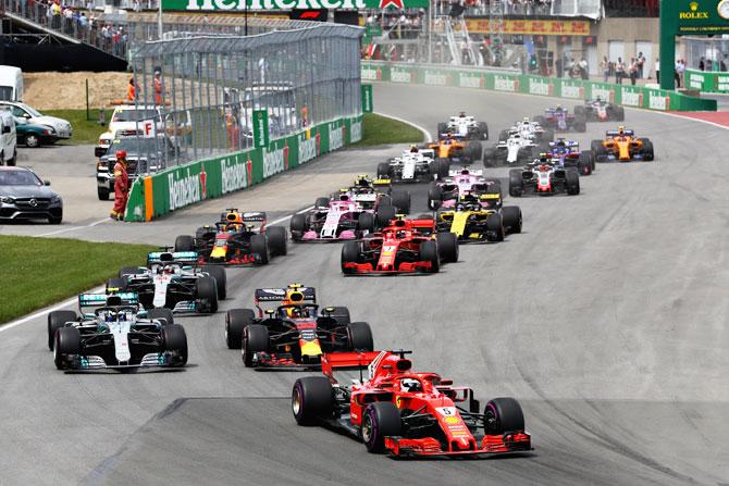 Sebastian Vettel driving the (5) Scuderia Ferrari SF71H leads the field at the start of the race