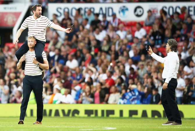 England's Lee Mack is carried by teammate Andrew Flintoff as John Bishop takes a photo prior to the Soccer Aid for UNICEF 2018 match