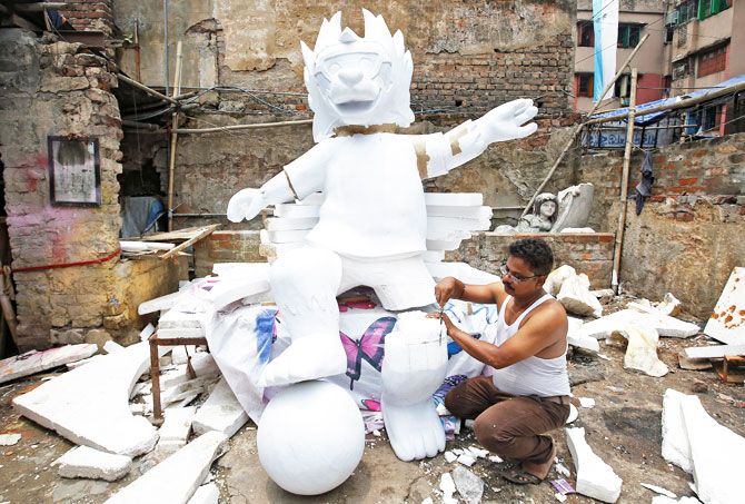 A man makes a replica of official mascot for the 2018 FIFA World Cup Russia at a workshop in Kolkata on June 11