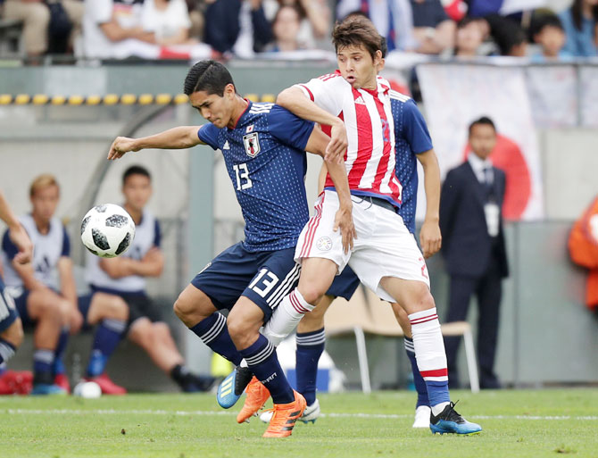 Japan's Yoshinori Muto in action with Paraguay's Oscar Romero vie for possession