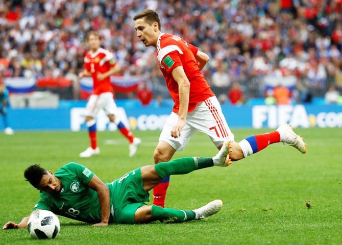 Saudi Arabia's Salem Al-Dawsari is challenged by Russia's Daler Kuzyayev