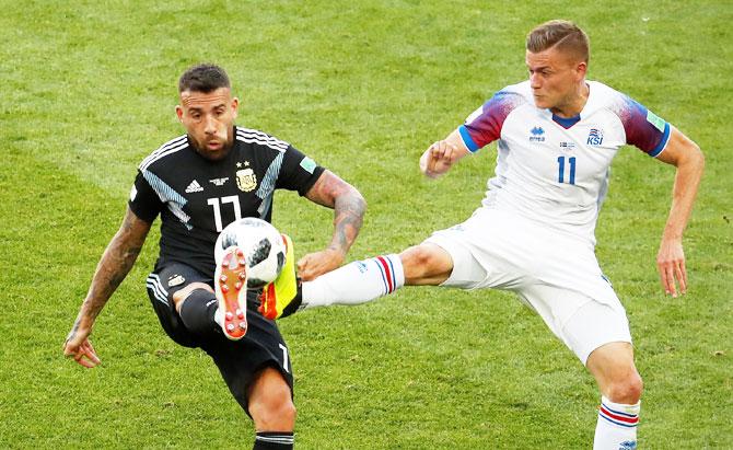 Argentina's Nicolas Otamendi and Iceland's Alfred Finnbogason vie for possession 