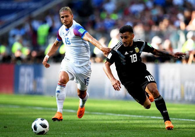 Argentina's Eduardo Salvio is challenged by Iceland's Rurik Gislason