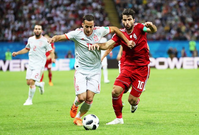 Iran's Karim Ansarifard battles for possession with Spain's Lucas Vazquez