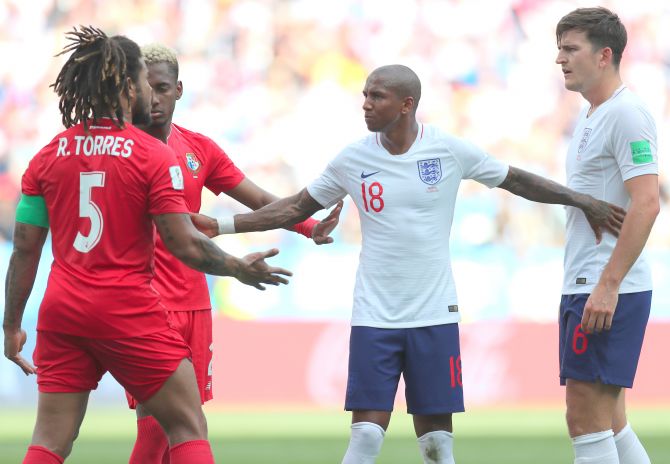 England's Ashley Young restrains teammate Harry Maguire and Panama's Roman Torres