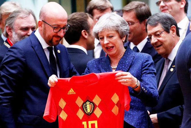 Britain's Prime Minister Theresa May receives Belgium's national soccer team jersey from Belgian Prime Minister Charles Michel as they attend an European Union leaders summit in Brussels, Belgium, on Thursday