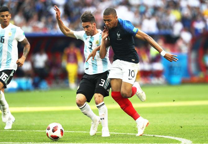 Argentina's Nicolas Tagliafico fouls France's Kylian Mbappe, leading to a free-kick outside the penalty area