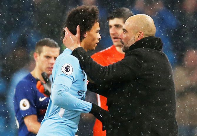 Manchester City manager Pep Guardiola celebrates with Leroy Sane after the match against Chelsea on Sunday