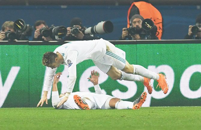 Real Madrid's Cristiano Ronaldo celebrates after Casemiro (on the ground) scores their second goal against Paris St Germain during the UEFA Champions League Round of 16 second leg match at Parc des Princes Stadium in Paris