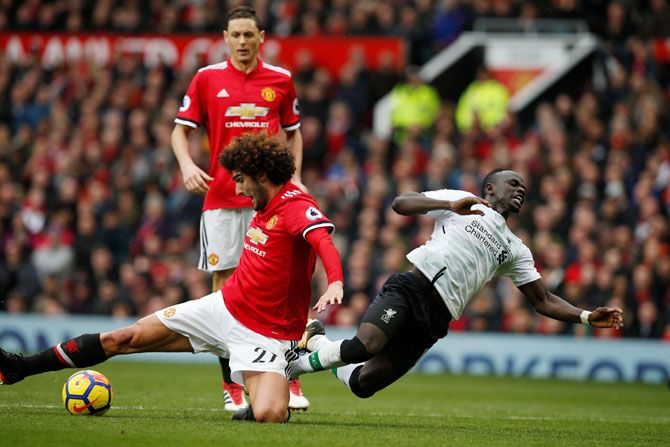 Manchester United's Marouane Fellaini in an ugly challenge with Liverpool's Sadio Mane