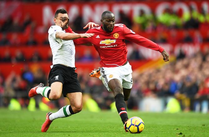 Manchester United's Romelu Lukaku runs with the ball under pressure from Liverpool's Dejan Lovren