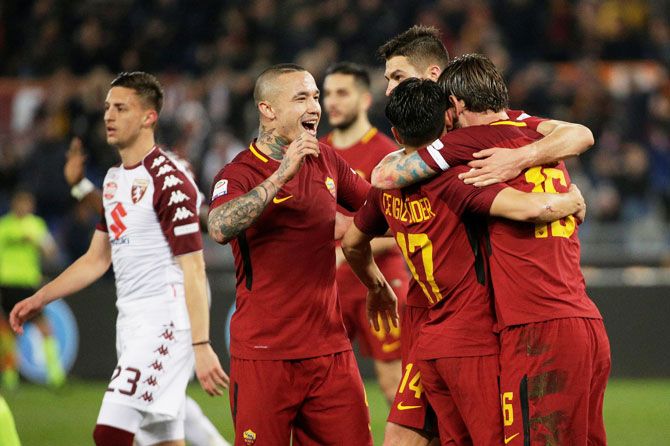 AS Roma's Daniele De Rossi celebrates with Radja Nainggolan and teammates after scoring their second goal against Torino in their Serie A match at Stadio Olimpico, Rome on Friday