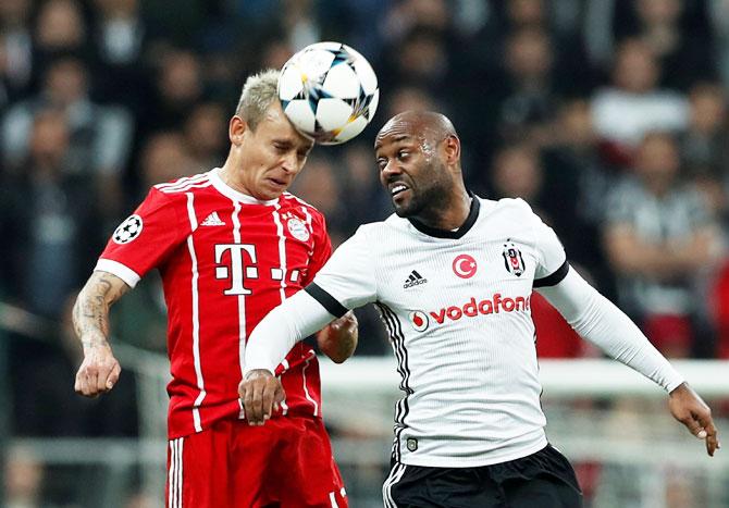 Besiktas' Vagner Love and Bayern Munich's Rafinha vie for the ball in an aerial challenge