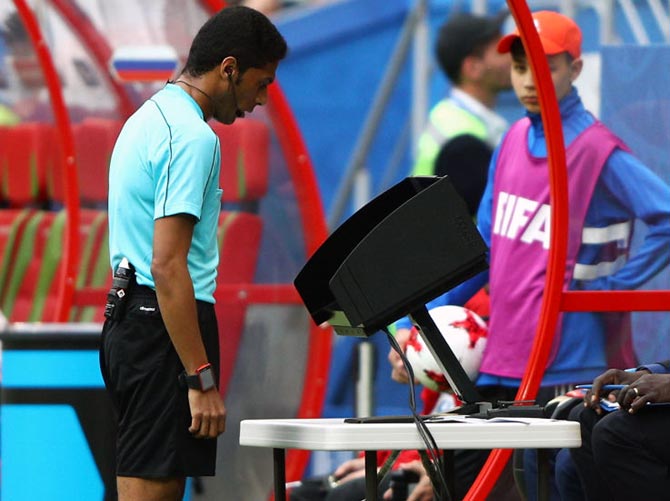 A referee reviewes the VAR footage