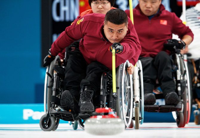 China's Wang Haitao throws the stone during the Wheelchair Curling Round Robin Session against South Korea