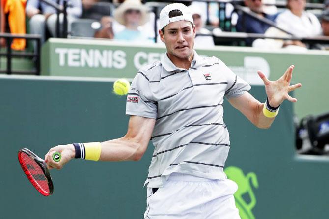 United States' John Isner hits a forehand against Korea's Hyeon Chung at Tennis Center at Crandon Park