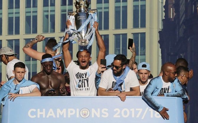 Manchester City players celebrate with the EPL trophy