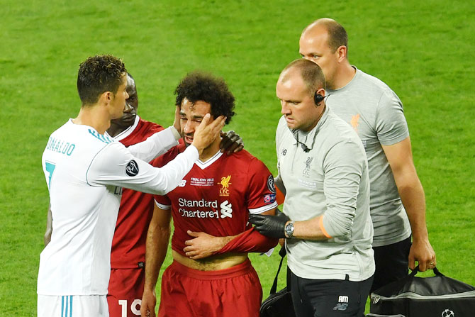Liverpool's Mohamed Mo Salah is consoled by Real Madrid's Cristiano Ronaldo as he is taken off the field following injury