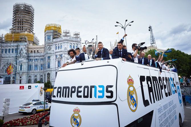 Real Madrid's captain Sergio Ramos (right) shows off the trophy to their fans with his teammate Marcelo (left) as they celebrate their Champions League trophy during the bus parade at Cibeles Square in Madrid on Sunday