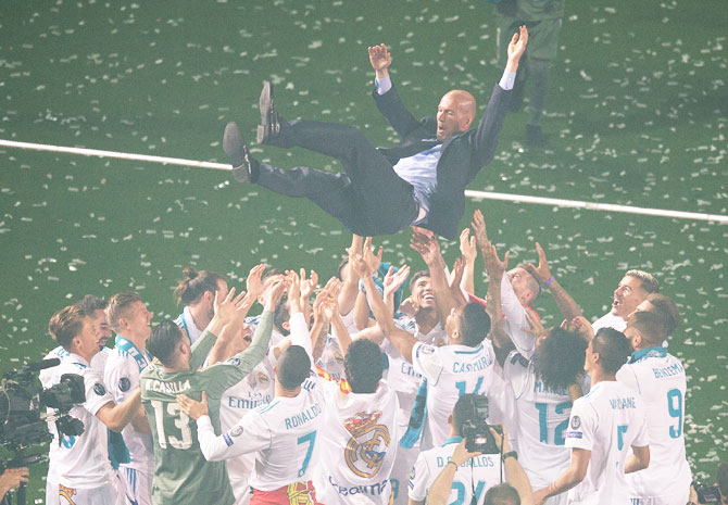 Real Madrid manager Zinedine Zidane is thrown in the air by his players during celebrations at the Santiago Bernabeu stadium on Sunday