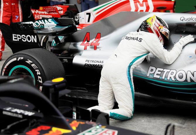 Lewis Hamilton kisses his car in celebration after winning the race