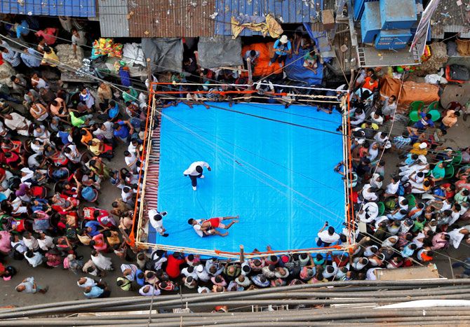 Wrestlers fight during an amateur wrestling match inside a makeshift ring installed on a road in in Kolkata. The bout was organised by local residents as part of Diwali celebrations on November 5