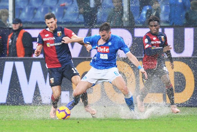Napoli's Fabian Ruiz is challenged by Genoa's Luca Mazzitelli and Stephane Omeonga during their Serie A match at Stadio Comunale Luigi Ferraris, in Genoa on November 10