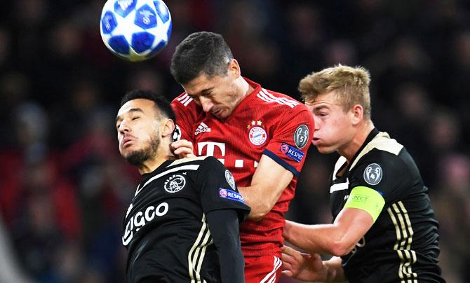 Ajax's Noussair Mazraoui and Matthijs de Ligt are involved in an aerial challenge with Bayern Munich's Robert Lewandowski