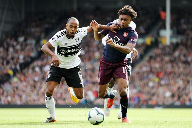 Arsenal's Alex Iwobi battles for possession with Fulham's Denis Odoi