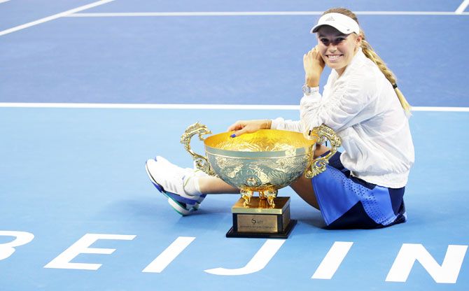 Denmark's Caroline Wozniacki celebrates with the trophy after winning the China Open women's singles final in Beijing, China, on Sunday