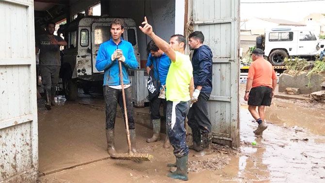 Rafael Nadal speaks to volunteers during the clean-up operations