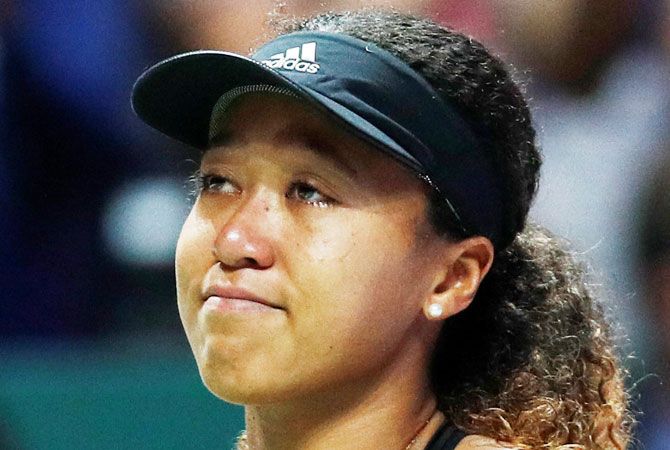 Japan's Naomi Osaka reacts after retiring from her group stage match against Netherlands' Kiki Bertens due to injury during the WTA Tour Finals at Singapore Indoor Stadium, in Kallang, Singapore on Friday