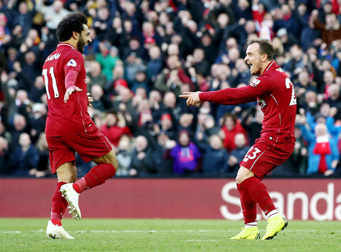 Liverpool's Xherdan Shaqiri celebrates with teammate Mohamed Salah after scoring his team's third goal against Cardiff City at Anfield in Liverpool on Saturday