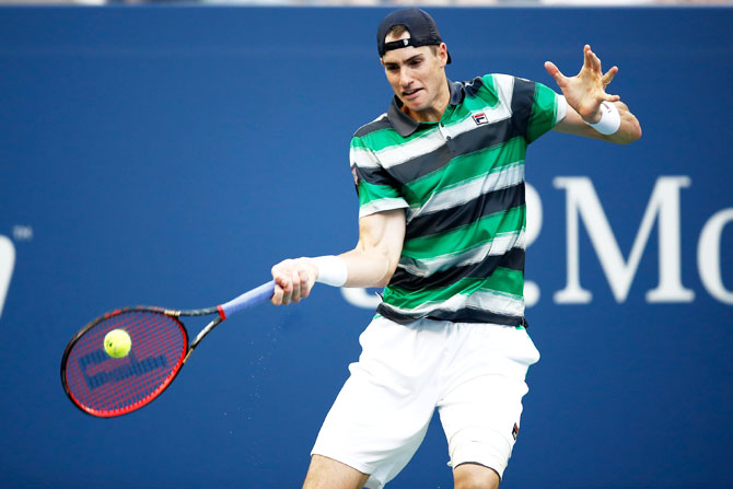 The United States' John Isner plays a return during the men's singles fourth round match against Canada's Milos Raonic