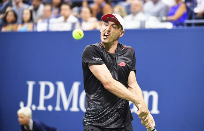 Australia's John Millman plays a return against Switzerland's Roger Federer