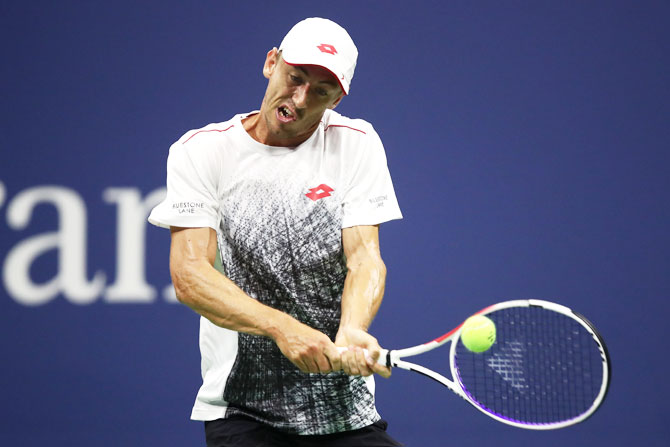 John Millman plays a return against Roger Federer