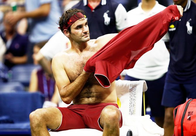Switzerland's Roger Federer changes his shirt in between games